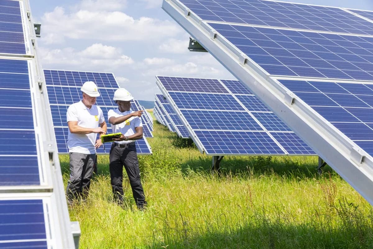 Güneş enerjisi santrali sahasında panel kurulumu yapan iki teknisyen