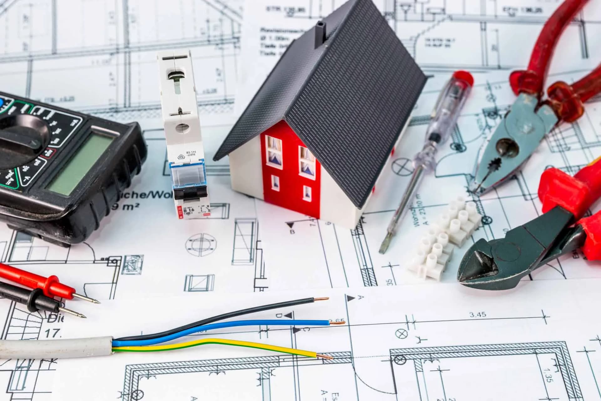 Elektrik projesi çizimi üzerinde multimetre ve montaj el aletleri